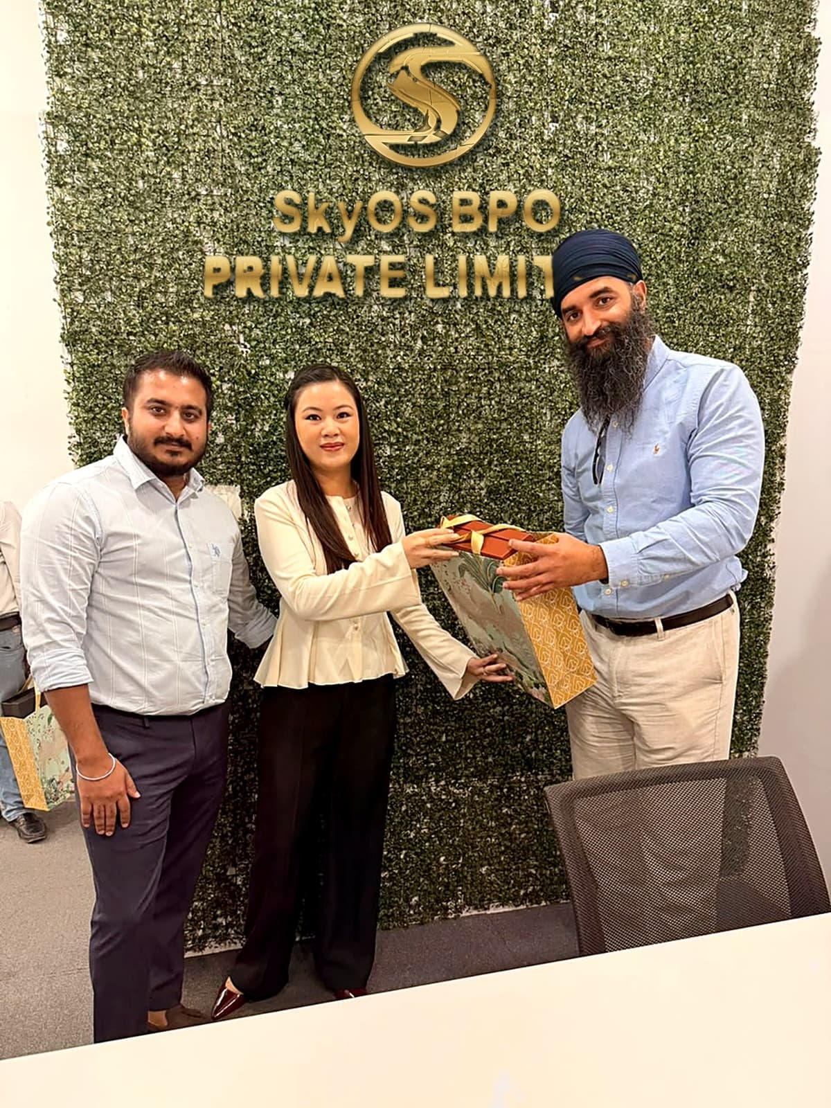 Team members exchanging gifts at the SkyOs BPO office